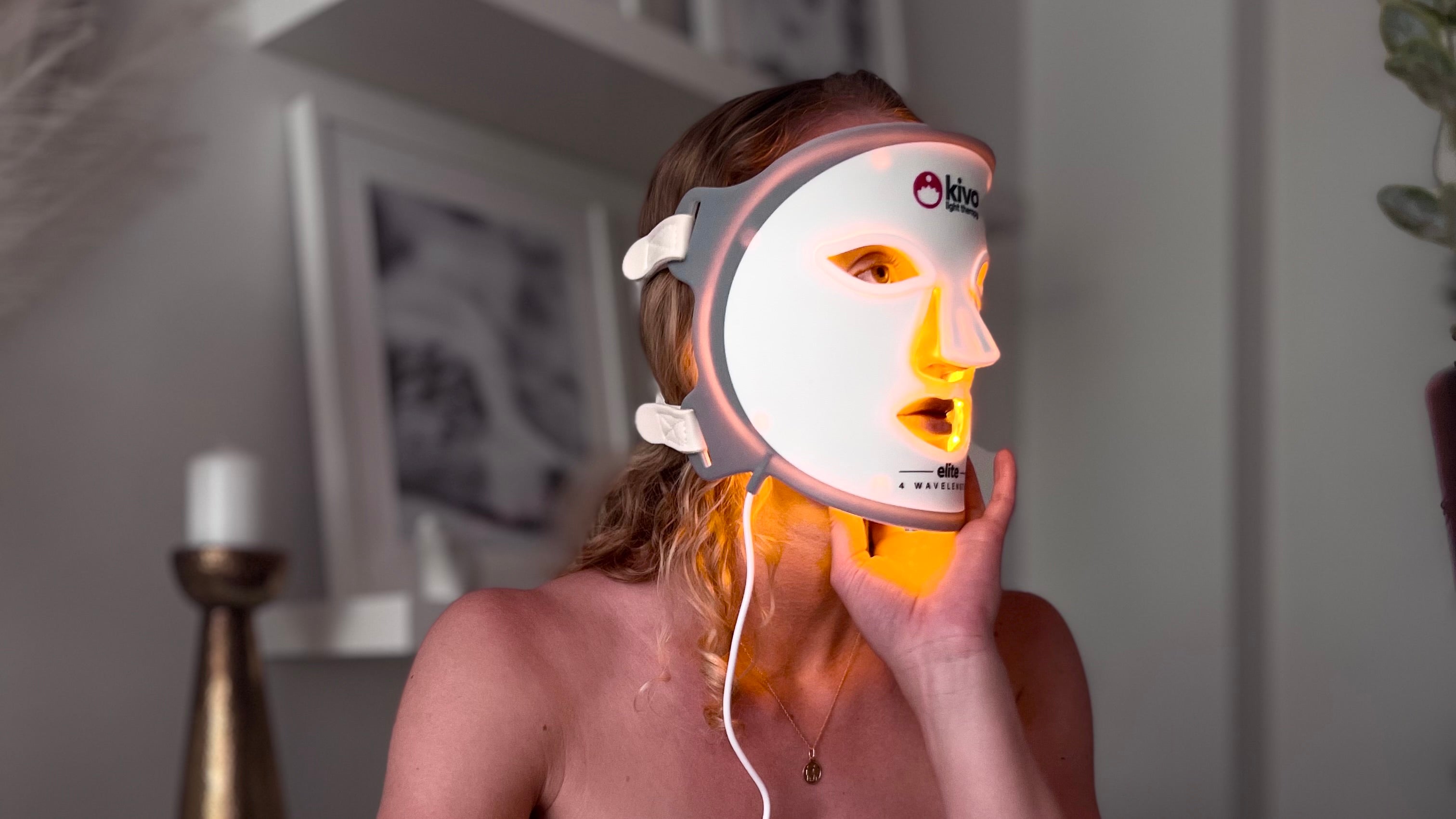 Woman wearing a Kivo LED face mask in a home setting